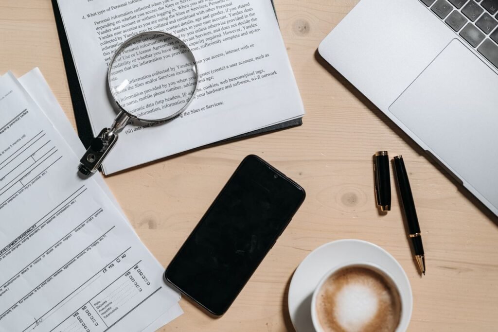 The Art of Drawing Readers In: Your attractive post title goes here Top view of documents, laptop, coffee, and magnifying glass on office desk.